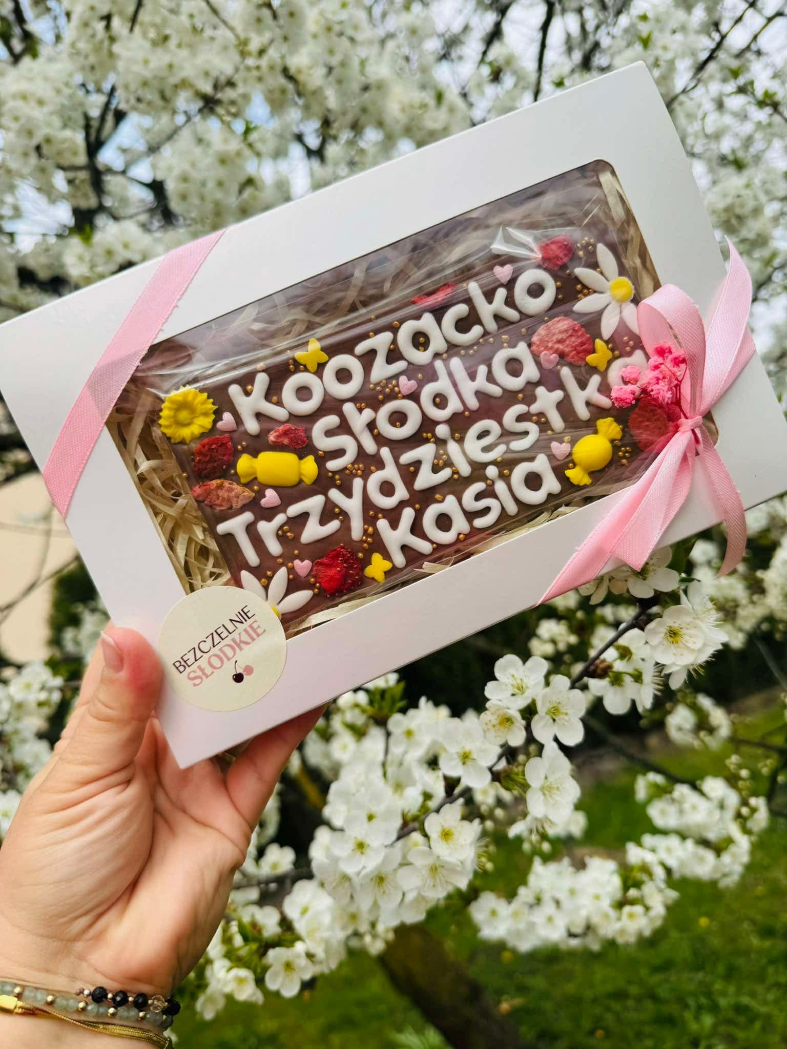 Zapakowana personalizowana czekolada Bezczelnie Słodkie z różową wstążką